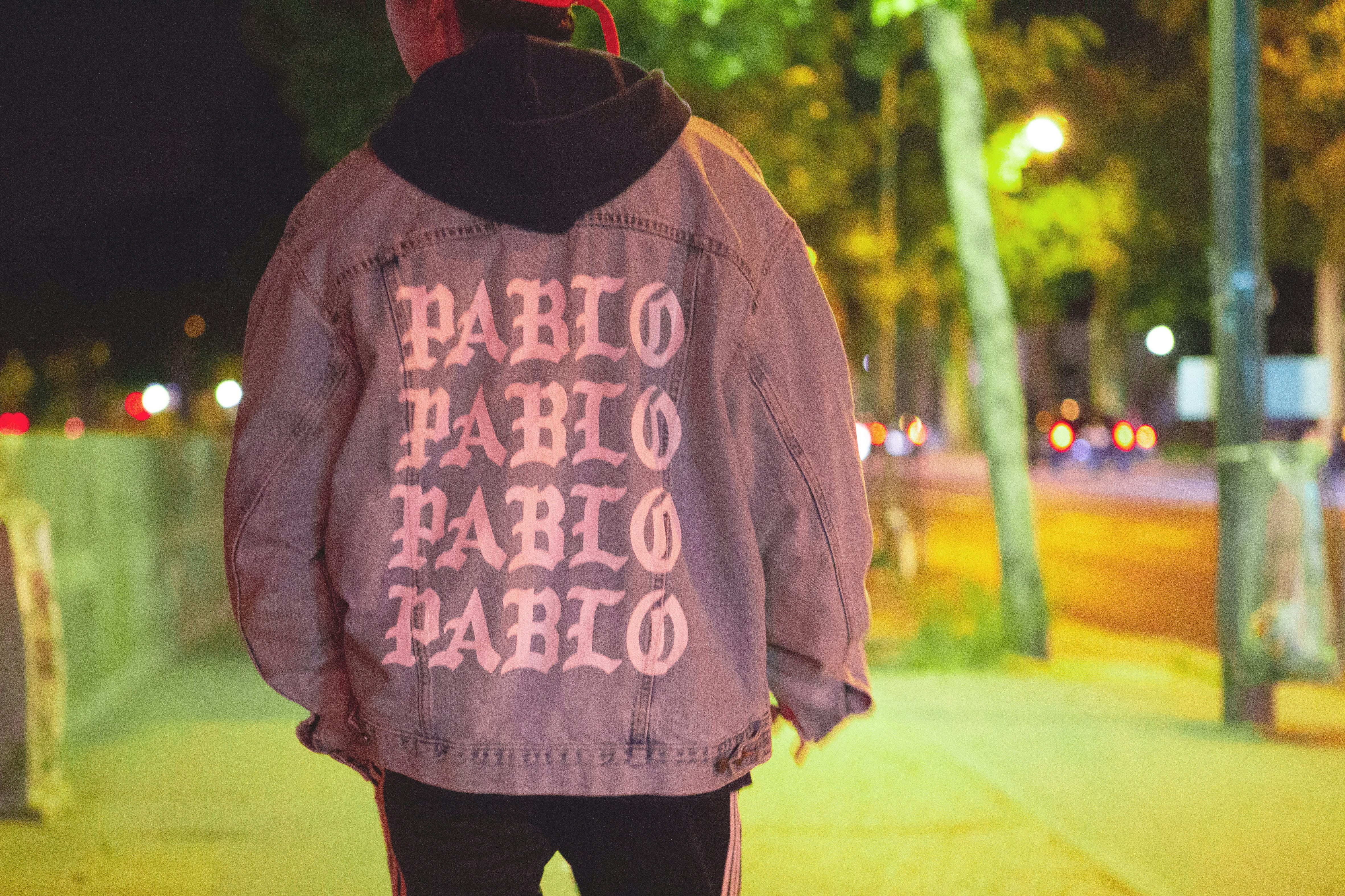 man wearing jacket standing on sidewalk